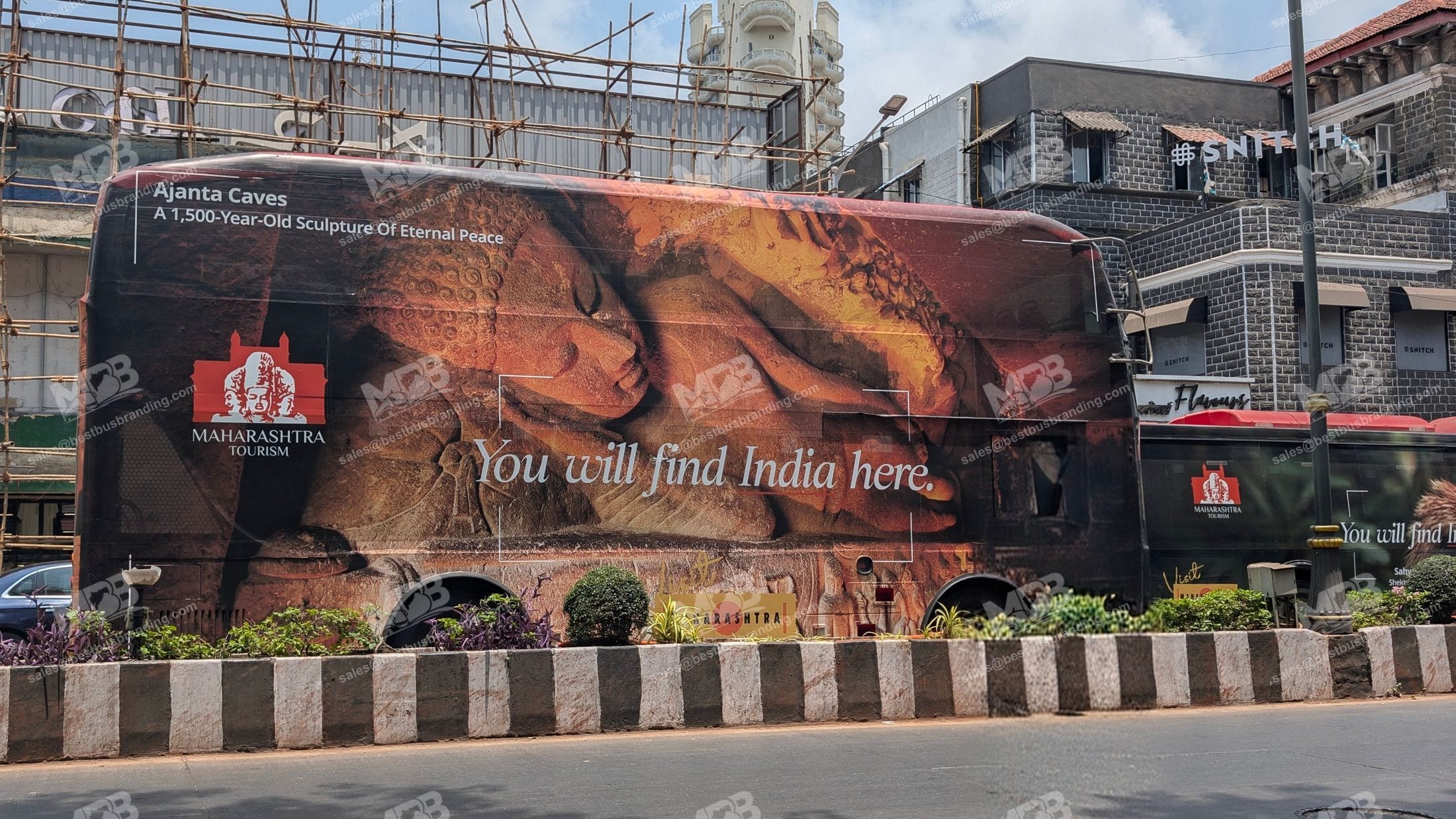 A BEST bus wrapped end to end for Maharashtra Tourism, parked on a Mumbai street